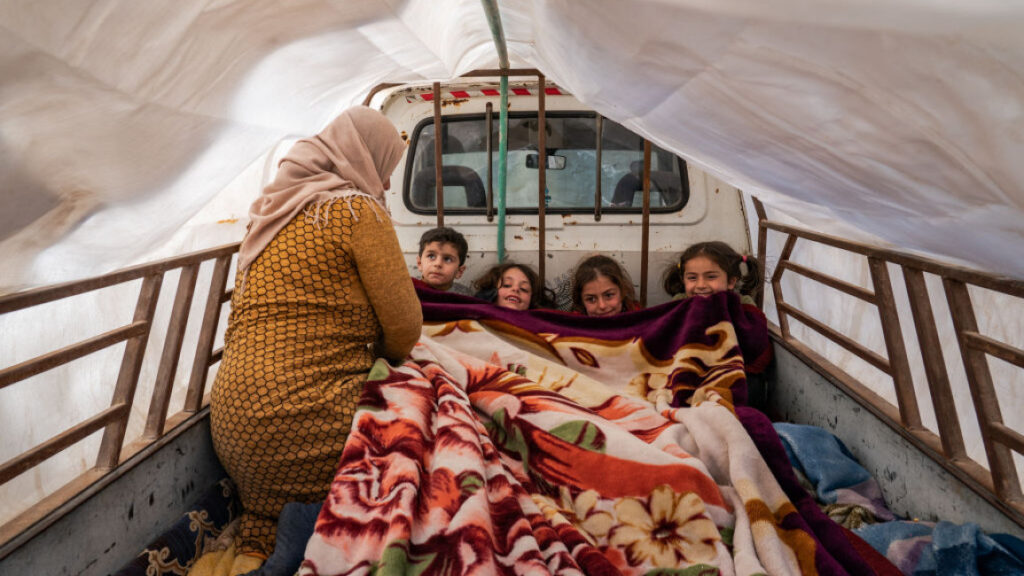 Yasmin, 30, covers her neighbour's children after their home was destroyed during a 7.8-magnitude earthquake that hit the region in the town of Jindires, Syria